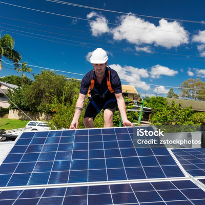 Monteur setzt ein Solarmodul auf ein Hausdach