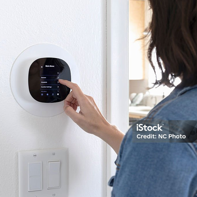 Hand bedient ein Wandpanel neben zwei Lichtschaltern