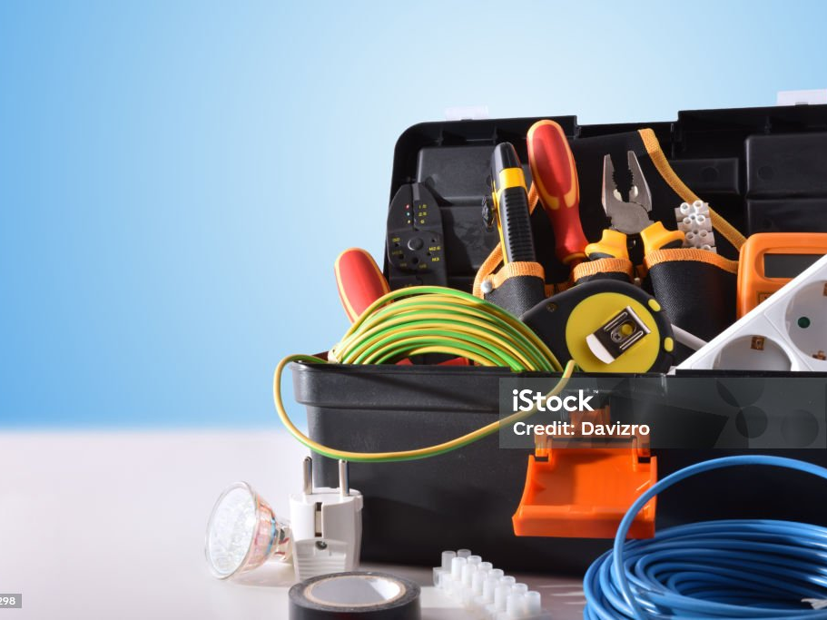 Geöffneter Werkzeugkoffer mit Elektrikerwerkzeug, Kabel und Steckdosenleiste